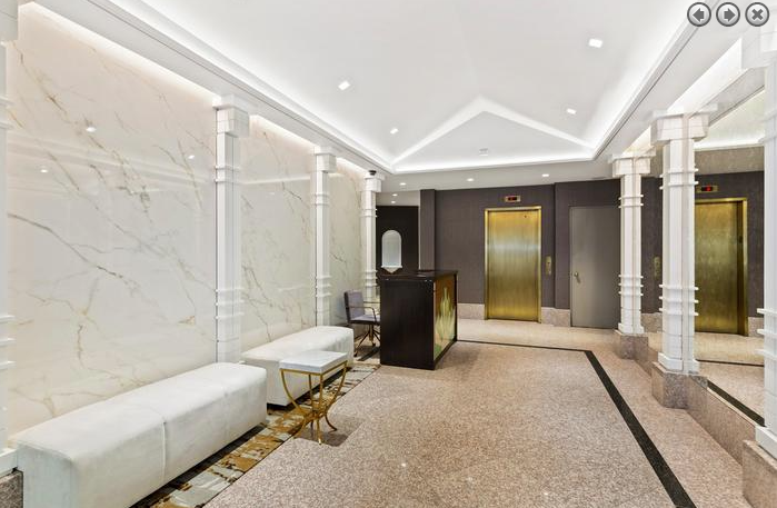 a lobby with white marble pillars and a reception desk